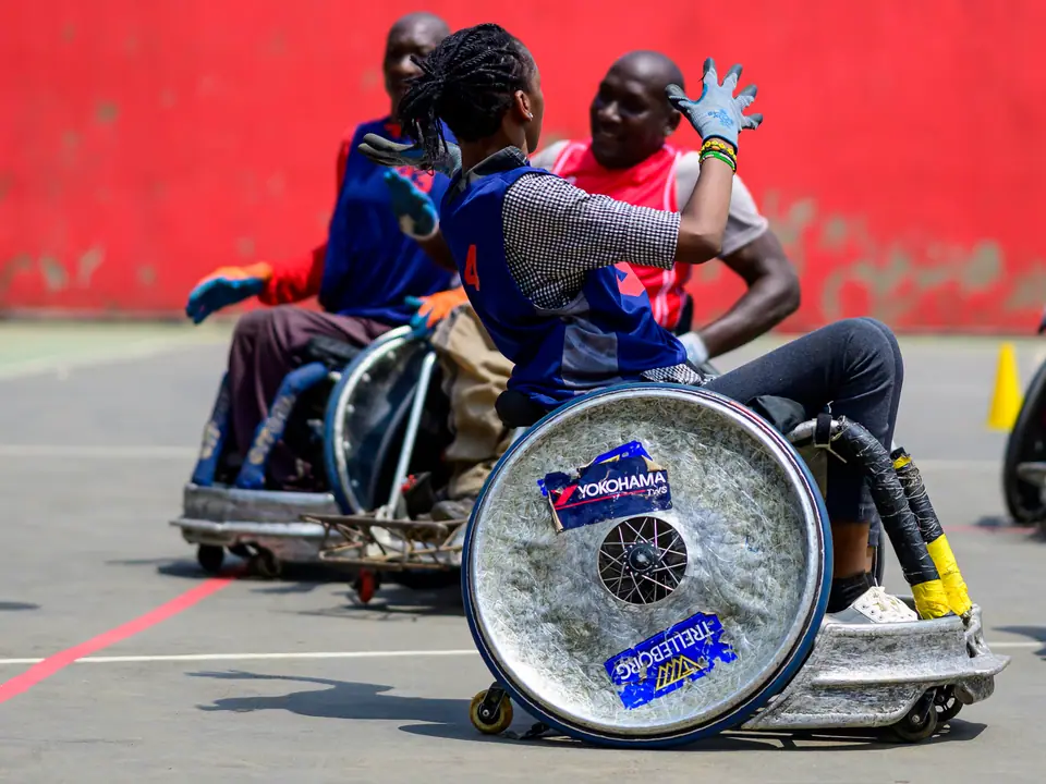 Athlete reaching for a ball during wheelchair rugby practice